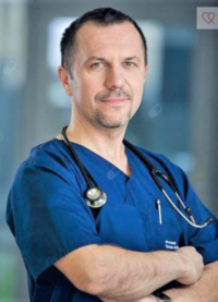 Mężczyzna w niebieskim kitlu, ze stetoskopem na szyi.