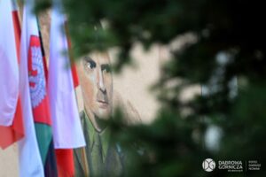 Fragment muralu przedstawiający portret gen. Andersa w mundurze. Z boku fragmenty ustawionych flag.