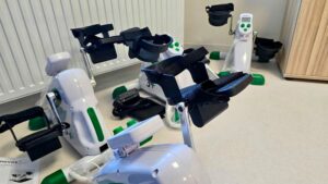 Przenośne urządzenia do ćwiczeń kończyn górnych i dolnych ustawione na podłodze w pomieszczeniu rehabilitacyjnym.